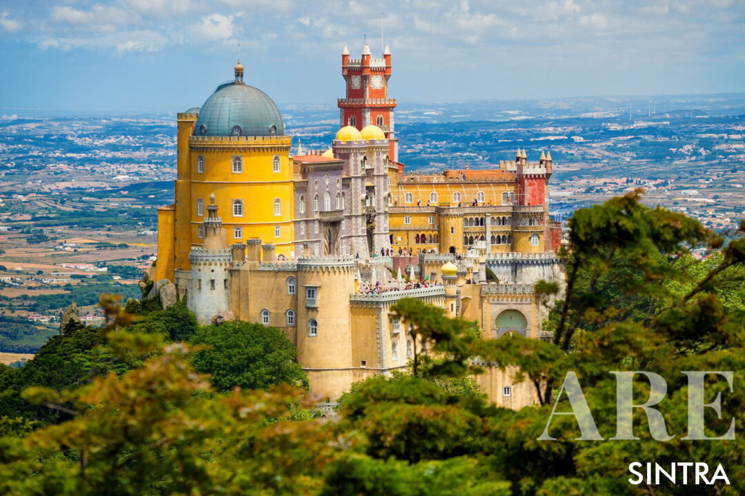 <em>El Palacio de Peña es uno de los monumentos más emblemáticos de Sintra y una de las principales atracciones para los visitantes.</em>El Palacio de Peña, ubicado en lo alto de una colina en las montañas de Sintra, es un castillo vibrante y romántico famoso por sus sorprendentes características arquitectónicas, caracterizadas por su vívida colores rojo, amarillo y azul.